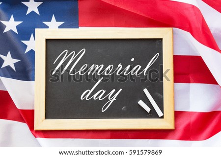 patriotism and national holidays concept - memorial day words on chalkboard, chalk and american flag