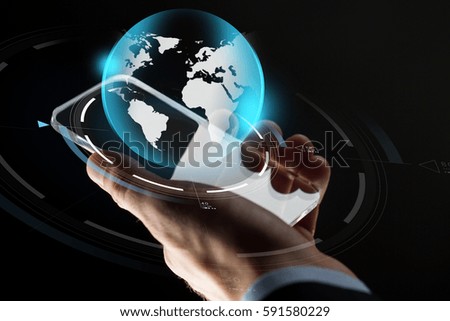 business, mass media, people and future technology concept - close up of businessman hand with transparent smartphone and virtual earth hologram over black background