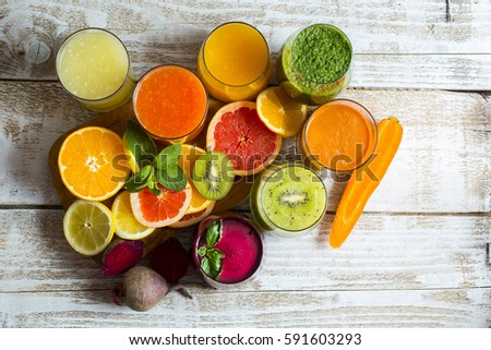Fresh detox juices from fruit and vegetables in glass bottles on a wooden background Royalty-Free Stock Photo #591603293