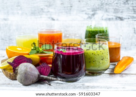 Fresh detox juices from fruit and vegetables in glass bottles on a wooden background Royalty-Free Stock Photo #591603347