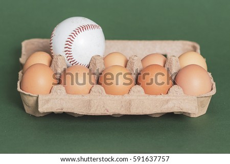 Baseball ball with eggs in carton