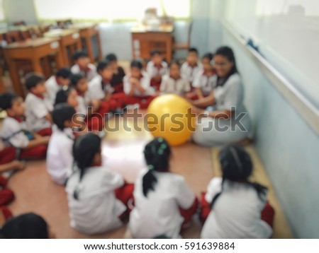 Blur kids and teacher in the  classroom for background usage.