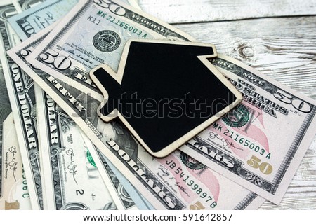 Concept image of USD's paper money with black mini house blackboard.
