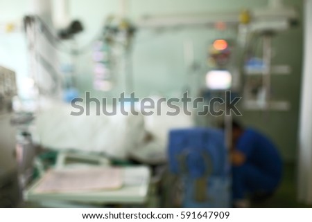 Hospital ward with sitting doctor and patient in bed, unfocused background.