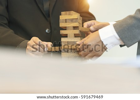  Selected focus right hand. Planning, risk and strategy of project management in business, businessman and engineer gambling placing wooden block on a tower.Business and construction concept.