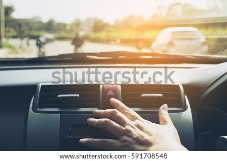 Man pushing emergency light button while driving car