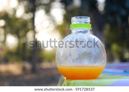 Orange juice in an orange bottle put on the table.
