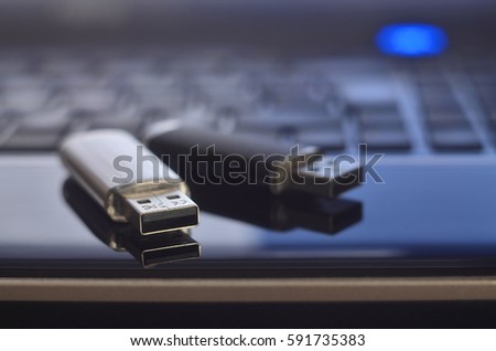 USB flash cards lying on black laptop case in front of his keyboard. Virtual memory storage with USB output Royalty-Free Stock Photo #591735383