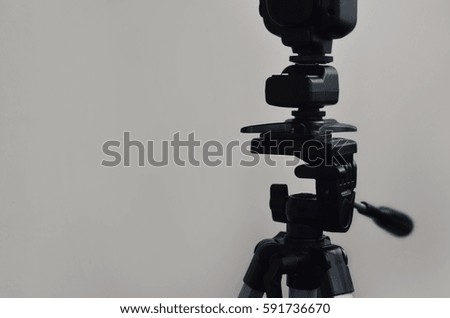External photographic flash is mounted on the synchronizer, which stands on a tripod. lighting equipment objects. Set of professional studio photographer
