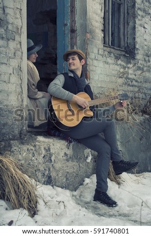 Happy couple in love on a date in the ruins old factory with guitar. Vintage style.