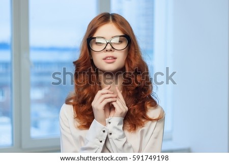 business woman with glasses wearing a white shirt against the backdrop of the city  