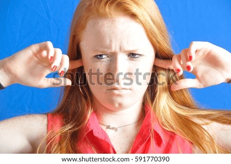 Teenage girl with her fingers in her ears.