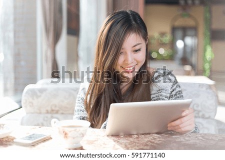 young pretty chinese woman sitting in modern cafe