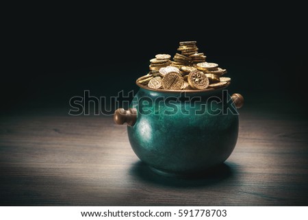 gold coins in a green pot on a dark background