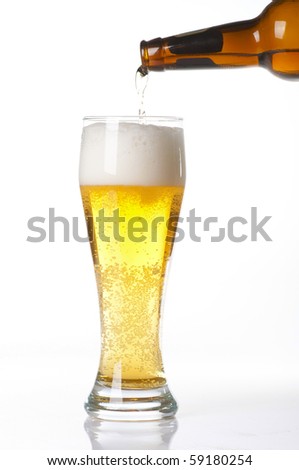 Beer pouring from bottle into glass isolated on white