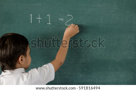 Children writing on blackboard at school  / soft focus picture 