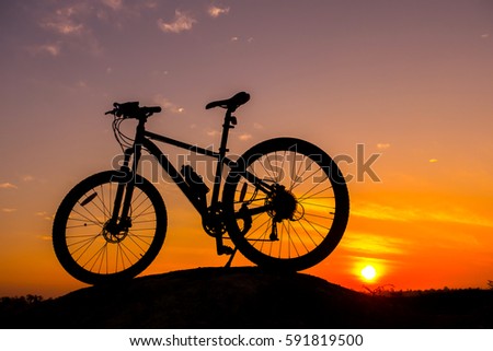 Bicycle silhouettes on the dark background of sunsets.Vivid sky and dark cloud.