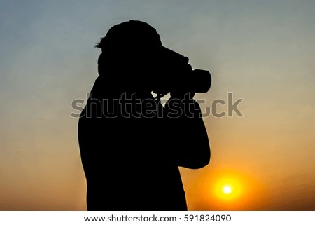 Silhouette of young photographer at sunrise