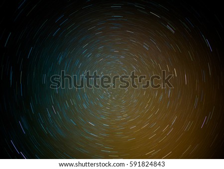 Direct view of the North Star. Star trails looks like colorful well. Blue and orange colors dominates the picture