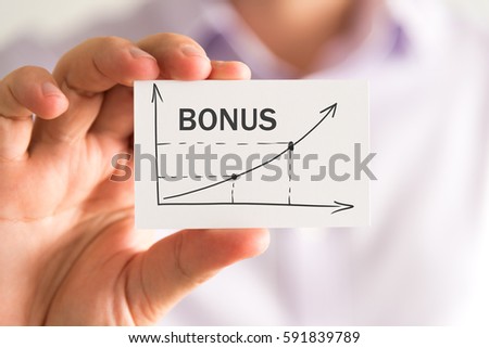 Closeup on businessman holding a card with BONUS rising arrow and chart, business concept image with soft focus background