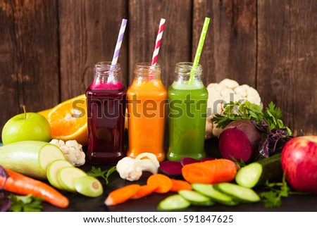 Freshly squeezed vegetable juice in bottles, useful vitamin cocktail, old wooden background, selective focus Royalty-Free Stock Photo #591847625