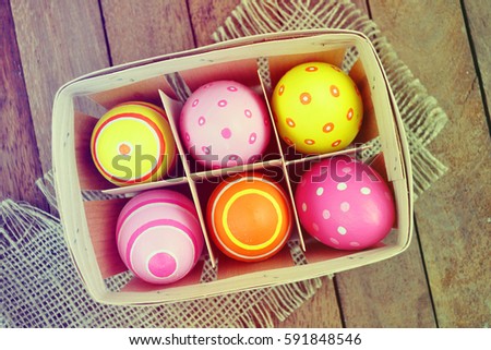 Easter eggs in basket. Wooden table. Seasonal background.