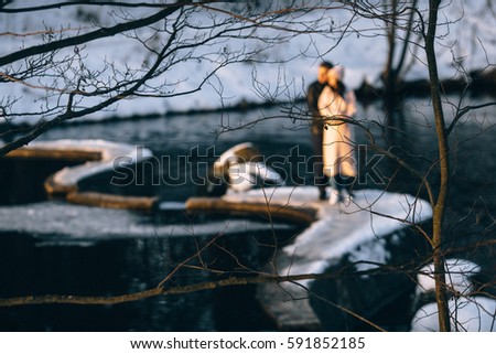 Happy couple in ice skates having fun outdoors with snow on background