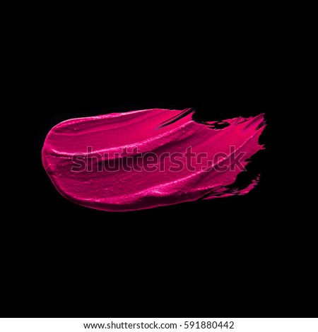 Pink purple lipstick smudged on a black isolated background