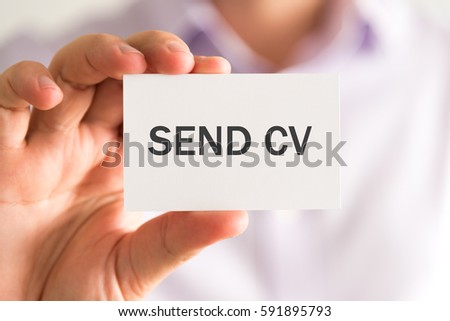 Closeup on businessman holding a card with SEND CV message, business concept image with soft focus background