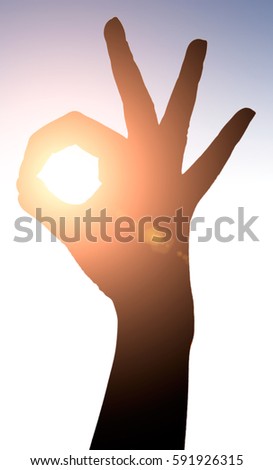 Raised hands catching sun on sunset sky. Concept of spirituality, wellbeing, positive energy etc.
