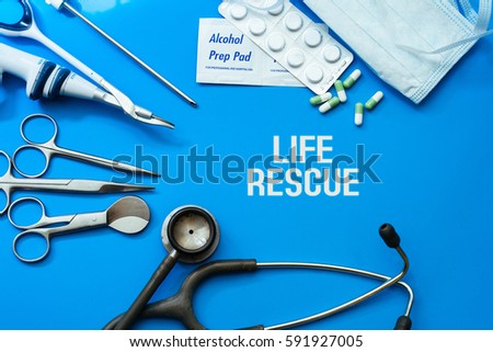 Medical concept, top view showing hospital instrument written LIFE RESCUE.