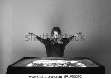 The woman draws on sand, sand animation, sand spilling out of two hands