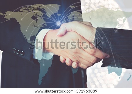 Double Exposure of businessman handshake on the background blurred bokeh nightlife of around the world with show social network structure on world map. The concept of an agreement.
