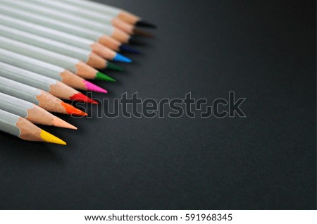 Drawing materials: pencils of different colors isolated on black background