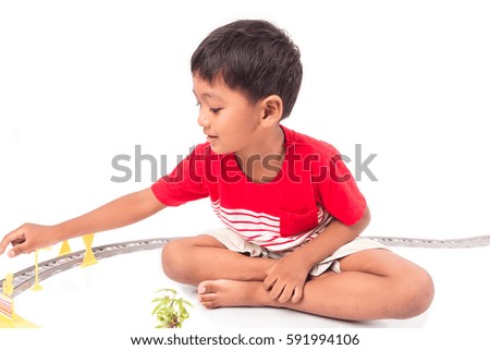 Cute asian boy play toy train on white background