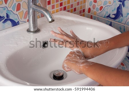 cloes up of hand girl washing hand with soap in toilet