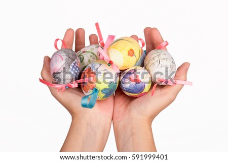 Colorful easter eggs in a clay hand isolated on white