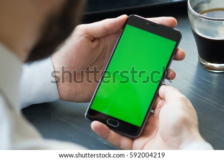 Business man using smart phone with green screen for internet and email. Sequence Royalty-Free Stock Photo #592004219