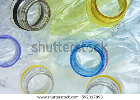 Close-up shot of stack of recyclable plastic bottles on white background.