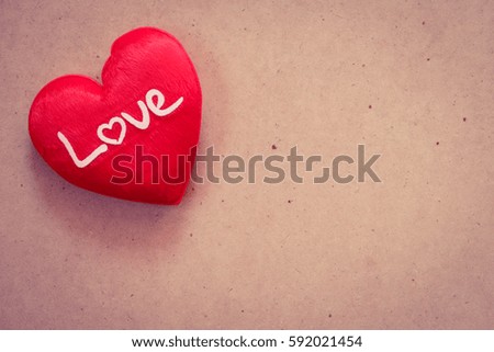 Red heart on brown paper background with copy space.