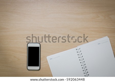 Top view Notebook ,smart phone on the desk is a wooden surface with copy space