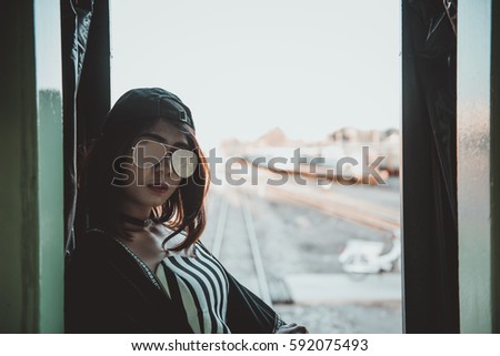 Hipster girl feeling sad  on the train in the evening japanese tone,vintage style,dark ton,film,pastel