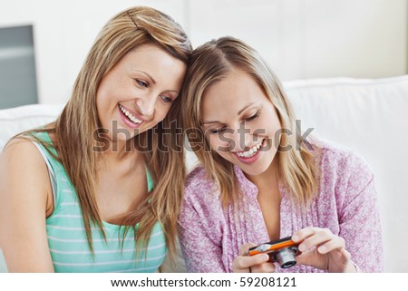 attractive friends looking at pictures sitting at home