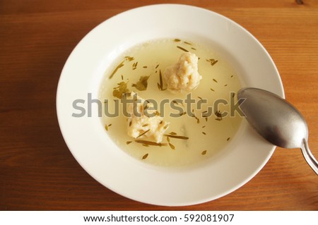 Chicken broth in white plate on wood background