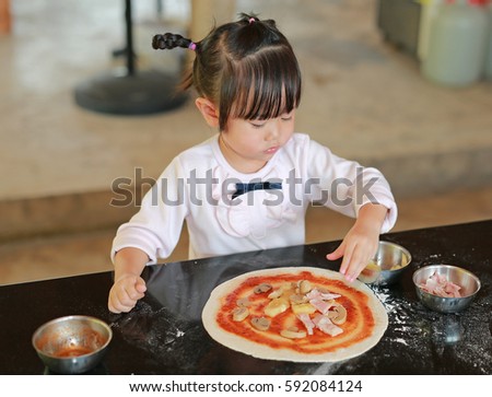 Little asian child girl making pizza
