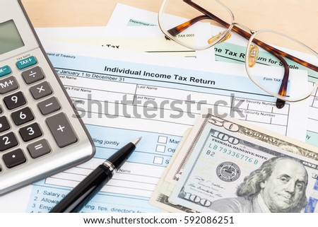 Tax form with calculator, pen, glasses, and dollar banknote; document are mock-up