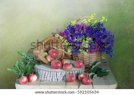 Still life of red and pink flowers. A bright bouquet of dried flowers in the basket . Color green and blue background.