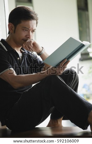 Man reading a book, serious expression