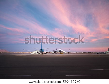 View at airport and airplanes at sunset from the terminal