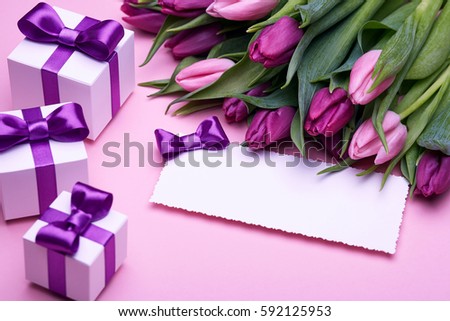 Greeting card, a bouquet of spring tulips, gifts in a beautiful package, bow from satin ribbon, a few boxes with gifts, the gift set on a pink background